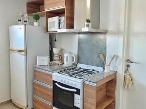 a small kitchen with a stove and a refrigerator at Cala in Olavarría