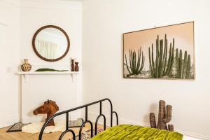 1 dormitorio con cama, espejo y cactus en La Casa, en Atlanta