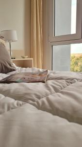 a white bed with a window in a bedroom at Cala in Olavarría