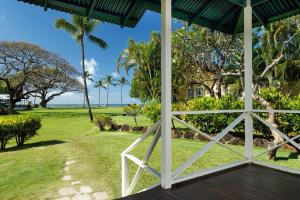 Una vista del océano desde el porche de una casa. en Waimea Plantation Cottages, a Coast Resort, en Waimea