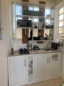 a kitchen with white cabinets and a sink at Cerca de Aeropuerto , bleseed house in Monte Adentro