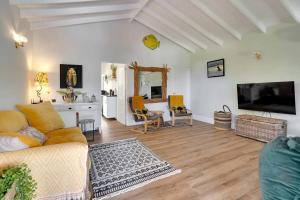 een woonkamer met een bank en een tv bij Lac Bay Casita 5 in Kralendijk +31 foto's