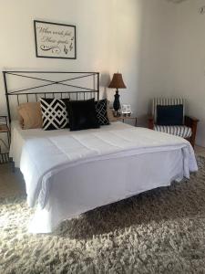 ein Schlafzimmer mit einem großen Bett mit weißer Bettwäsche und Kissen in der Unterkunft Descansa y viaja bleseed house in Monte Adentro