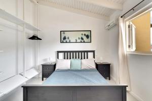 - une chambre avec un lit doté de draps bleus et une fenêtre dans l'établissement Kas Kontentu in Caribbean Court, à Kralendijk