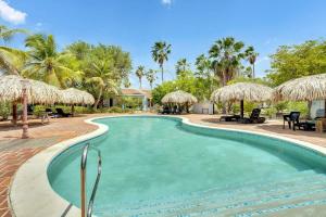 - une piscine dans un complexe avec des palmiers dans l'établissement Kas Kontentu in Caribbean Court, à Kralendijk