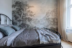 a bed in a bedroom with a wall mural at Monciak Comfort - Alejki in Sopot