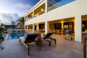 a living room with a pool and a house at Tres Ojos in Sabadeco in Kralendijk