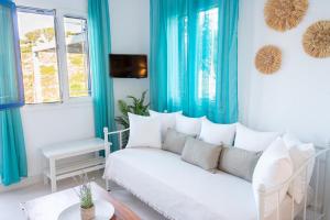a living room with blue curtains and a white couch at Eleftheria's Place in Patmos