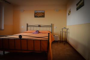 a bedroom with a bed with an orange blanket at Agriturismo Airone Eco Bio in Pitigliano