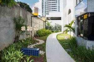 een loopbrug in een tuin naast een gebouw bij Jaqueira Home Service in Recife