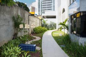 uma passarela num jardim ao lado de um edifício em Jaqueira Home Service no Recife