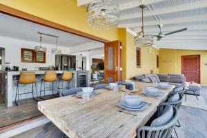 ein Esszimmer und ein Wohnzimmer mit einem Holztisch und Stühlen in der Unterkunft Kas Pura Vida in Belnem in Kralendijk