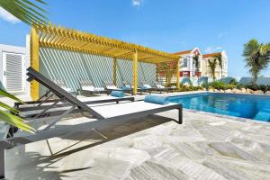 a pool with lounge chairs and a swimming pool at Liv Inn Bonaire with Pool and Nice Cooling Winds in Kralendijk