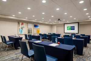 a conference room with tables and chairs and a screen at Holiday Inn Express Hotel & Suites McDonough, an IHG Hotel in McDonough