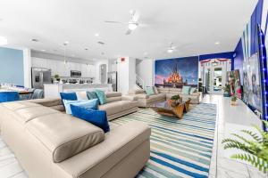 a living room with couches and a kitchen at Luxury 15BR - Pool, Hot Tub, Theater Room & More! in Kissimmee