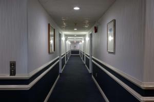 un pasillo de un pasillo con paredes blancas y un pasillo largo en Coast Parksville Hotel en Parksville