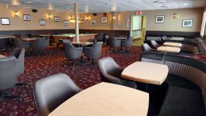 een wachtkamer met banken, tafels en stoelen bij Eldorado, a Coast Hotel in Dawson City