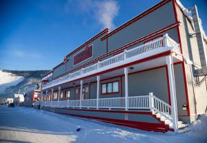 un edificio con nieve en el suelo junto a una montaña en Eldorado, a Coast Hotel, en Dawson City
