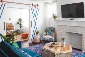 ein Wohnzimmer mit einem blauen Sofa und einem Kamin in der Unterkunft Parkfront Lux in Atlanta