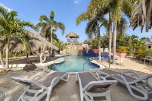a swimming pool with chairs and a gazebo at Casa Magnolia Communal Pool and Outdoor Shower in Kralendijk