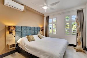 a bedroom with a large bed and a ceiling fan at Kas Ereda Ground floor Apartment with Pool in Kralendijk +27 photos