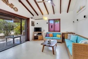 a living room with a blue couch and a table at Casa Magnolia Communal Pool and Outdoor Shower in Kralendijk