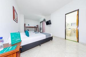 a bedroom with a large bed and a bathroom at Hotel Balcones 70 Laureles in Medellín