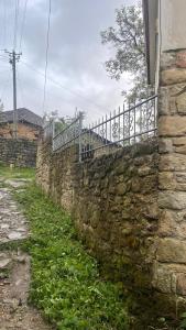 a stone wall with a fence on top of it at Bitro House in Pogradec