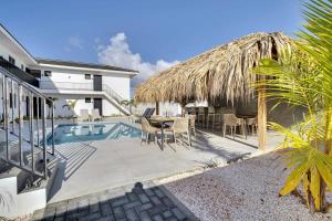 a patio with a table and chairs next to a house at Villa Valena Apartment 1 with Cooling Pool in Kralendijk