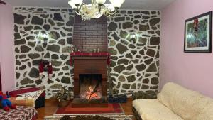 a fireplace in a living room with a stone wall at Bitro House in Pogradec