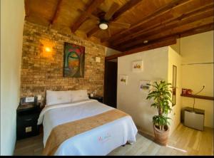 a bedroom with a large bed and a brick wall at Hotel Villas Mariposas in Atlixco