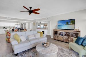 sala de estar con sofá blanco y ventilador de techo en Admirals Quarters 1009, en Orange Beach