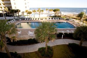 a large swimming pool with palm trees and the ocean at Seaside Beach Racquet 3504 in Orange Beach
