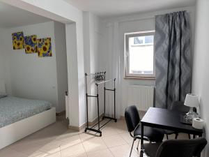 een slaapkamer met een bed, een bureau en een tafel bij Apartamenty Gołębia-Budget in Poznań