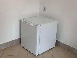 een witte koelkast in een hoek van een kamer bij Apartamenty Gołębia-Budget in Poznań