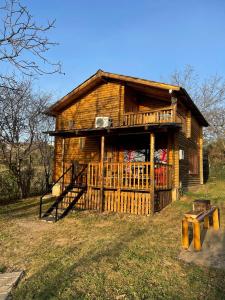 a log cabin with a porch and a deck at Villzone vila in Prishtina with big garden in Pristina