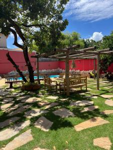 un parc avec des bancs, un arbre et une piscine dans l'établissement Pousada Flor de Pequi, à La Serra do Cipo