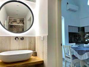 ein Badezimmer mit einem weißen Waschbecken und einem Spiegel in der Unterkunft Casa Cecilia - Puglia Mia Apartments in Monopoli