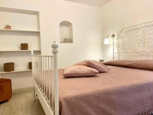 ein Schlafzimmer mit einem weißen Bett mit rosa Kissen in der Unterkunft Casa Cecilia - Puglia Mia Apartments in Monopoli