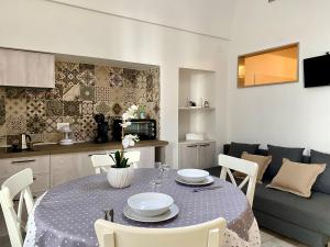 eine Küche und ein Wohnzimmer mit einem Tisch und einem Sofa in der Unterkunft Casa Cecilia - Puglia Mia Apartments in Monopoli