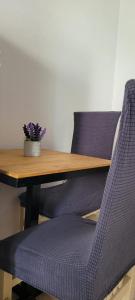 une table en bois avec deux chaises violettes et une table avec une plante dans l'établissement Tirana Central Home, à Tirana