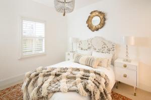 a white bedroom with a bed and a mirror at Boutique La TiQue in Atlanta