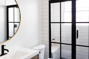 La salle de bains blanche est pourvue d'un miroir et d'un lavabo. dans l'établissement Bohemian Bliss, à Atlanta
