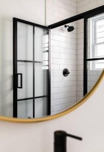 a bathroom with a shower with a round mirror at Bohemian Bliss in Atlanta