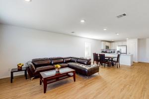 a living room with a leather couch and a table at Relax or Play in Baytown