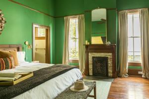 a green bedroom with a bed and a fireplace at Pecan Park in Atlanta