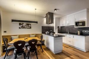 een keuken en eetkamer met een tafel en stoelen bij Chalet Prades Dolomiti Lodges in La Villa