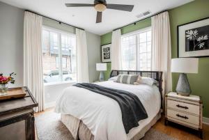 亞特蘭大的住宿－Bird's Eye View，一间带绿色墙壁的卧室和一张带吊扇的床