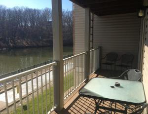 a porch with a table and chairs and a view of a river at Lake Condo with Heated Pool and Hot Tub at Lake Ozark in Osage Beach