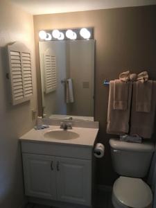 a bathroom with a sink and a toilet and a mirror at Lake Condo with Heated Pool and Hot Tub at Lake Ozark in Osage Beach